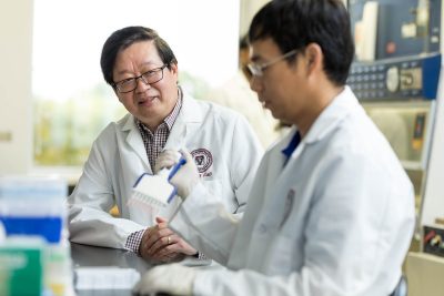 X.J. Meng (at left) working with members in his lab.