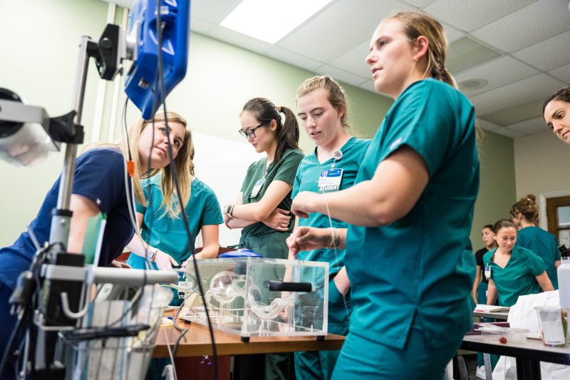 A group of Virginia Tech MSND students take place in an activity to test their feeding tube insertion skills.