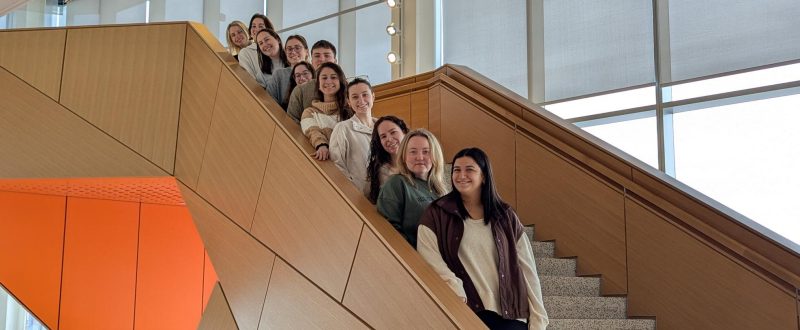 Internship students stand on the stairs in Academic Building One