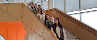 Internship students stand on the stairs in Academic Building One