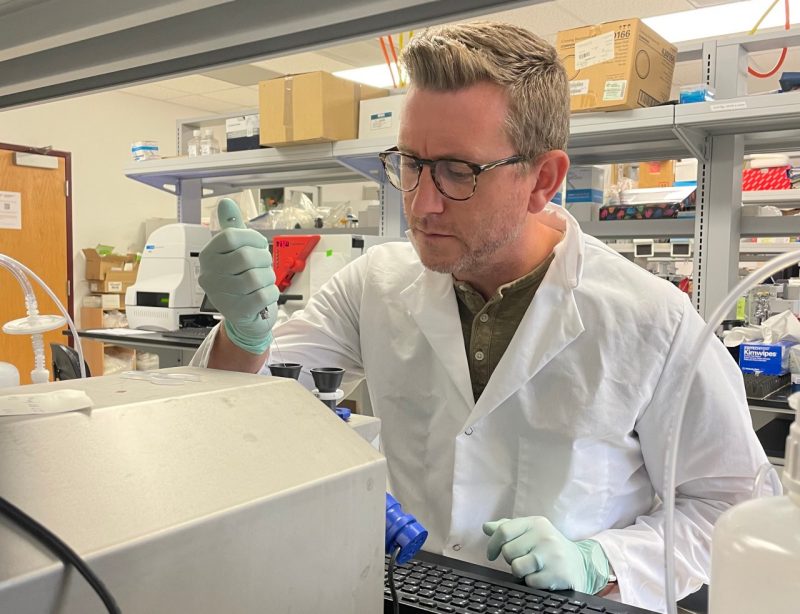 A professor looks intently at an experiment being conducted in his lab.