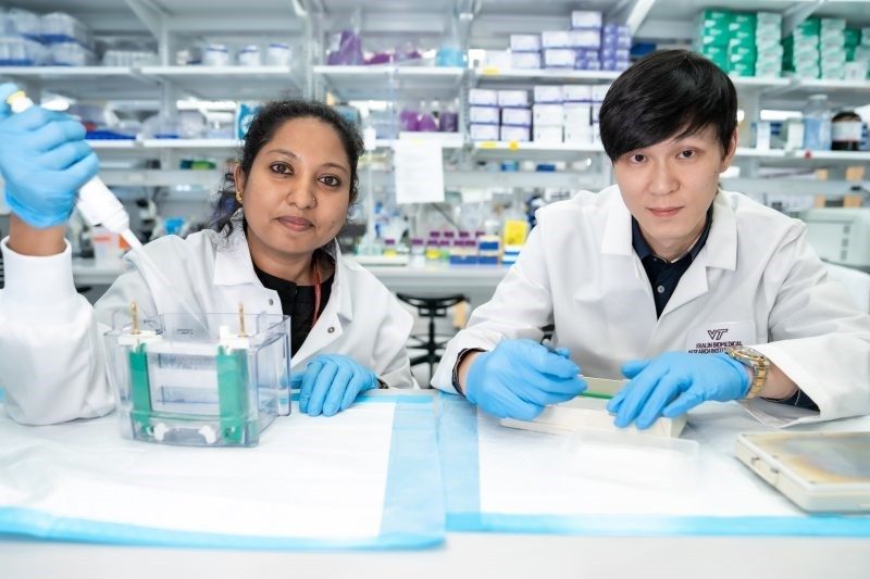 Two researchers posing for a photo inside of a lab.