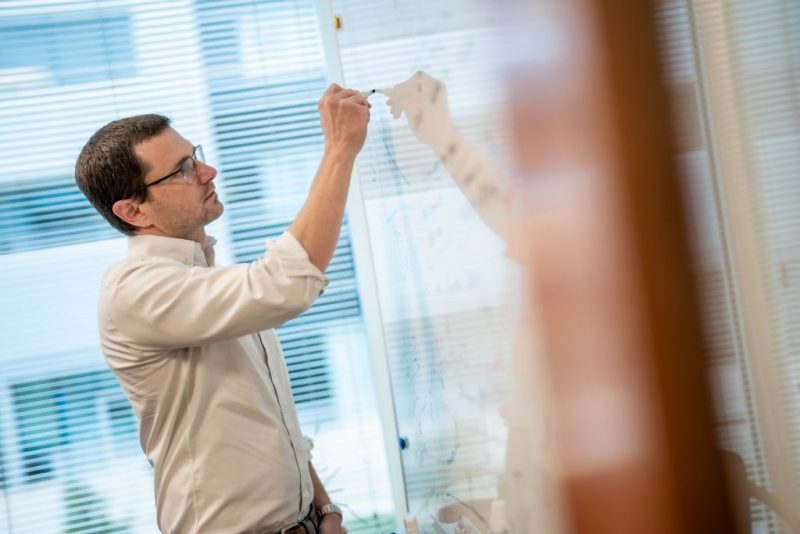 A Virginia Tech HNFE faculty member writing on a white board.