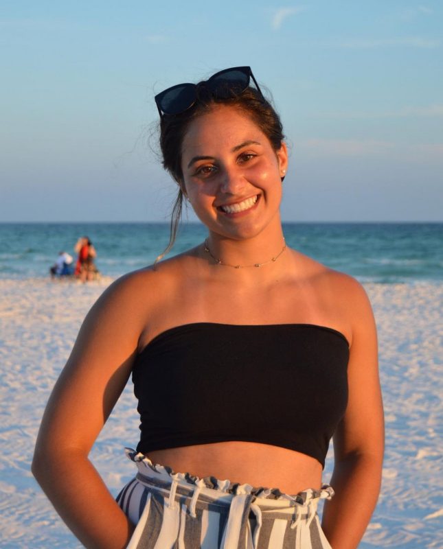 A Virginia Tech HNFE Ambassador stands at the beach for a photo.